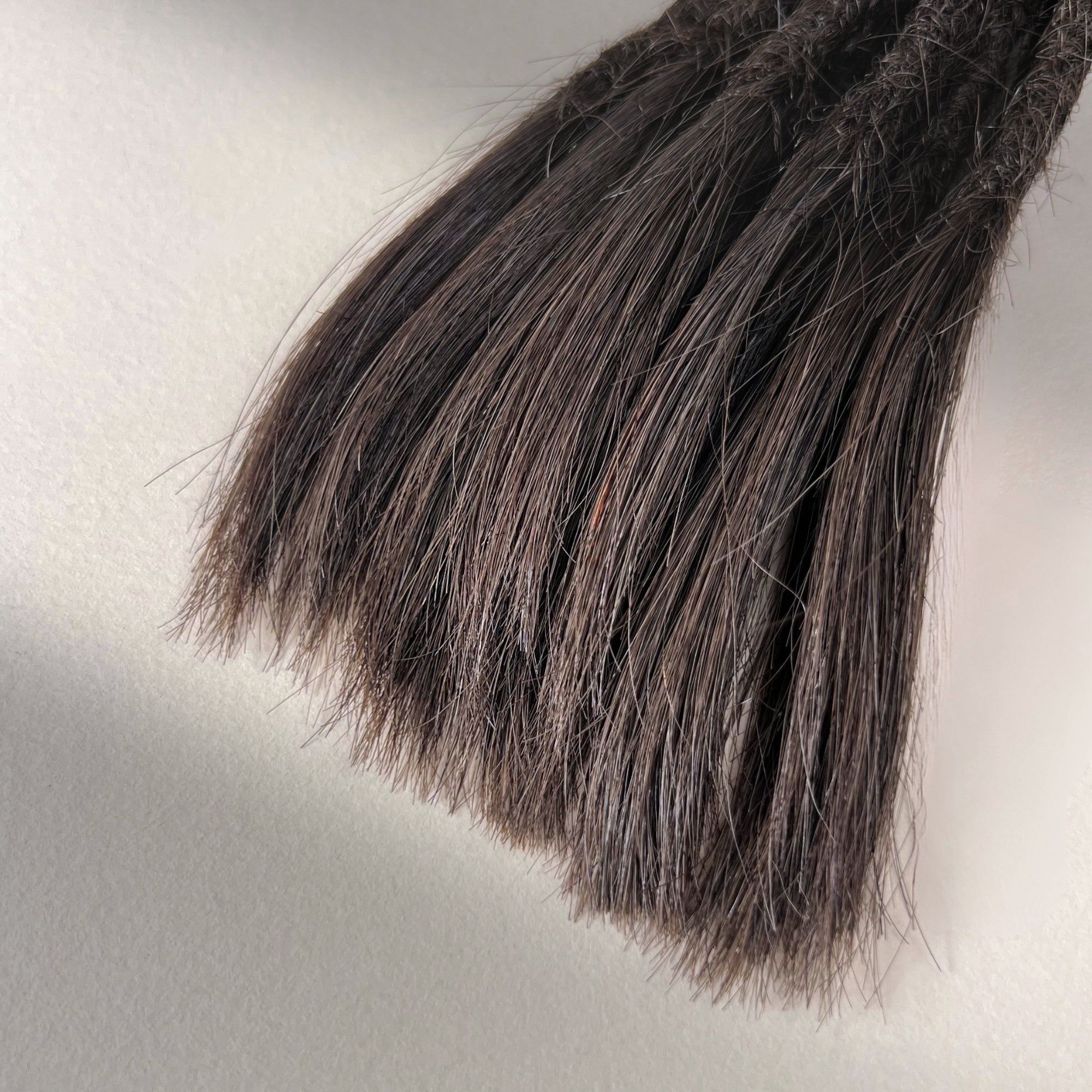 Tip detail of straight loc extensions with open ends in Warm Espresso Brown.