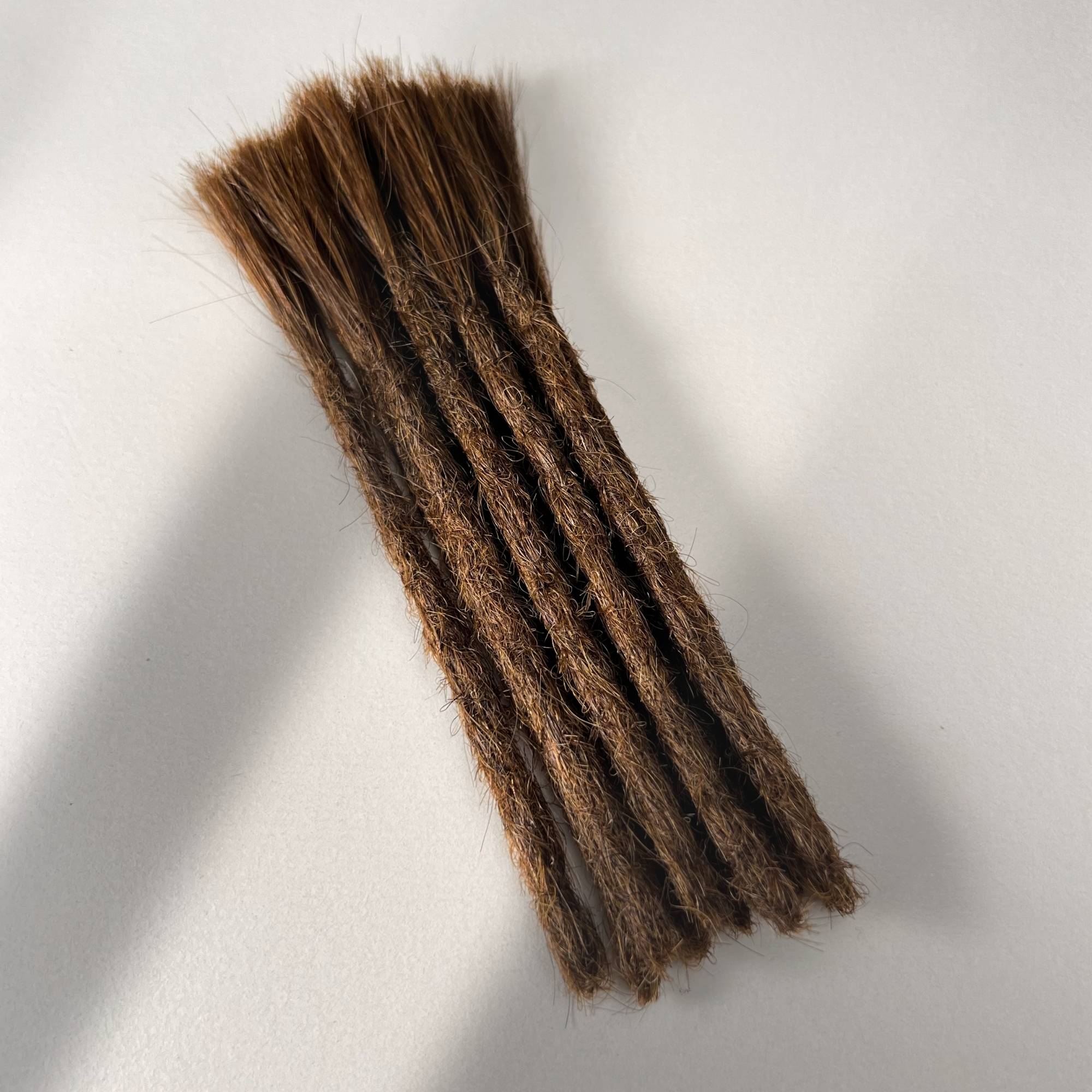 Full view of permanent straight loc extensions with blunt ends in Warm Golden Brown.