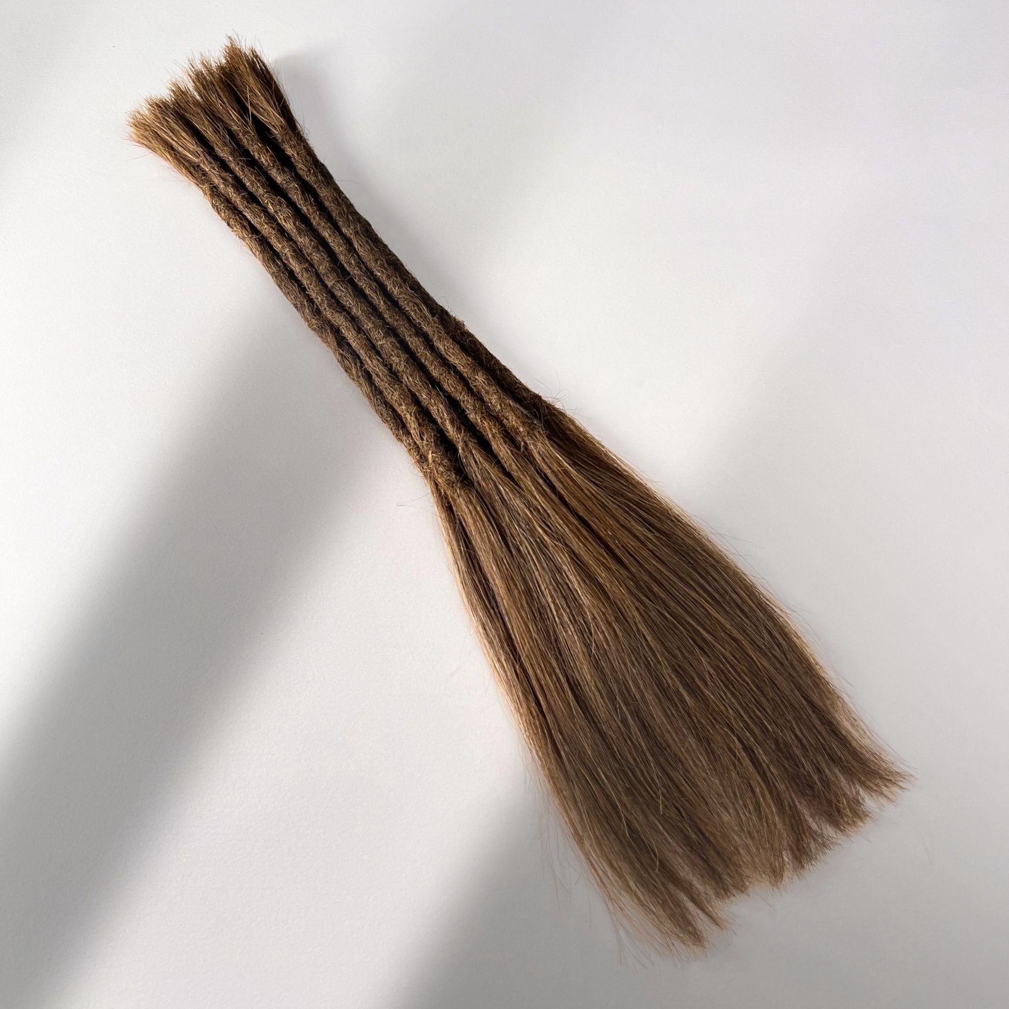 Full view of permanent straight loc extensions with long loose ends in Warm Golden Brown.