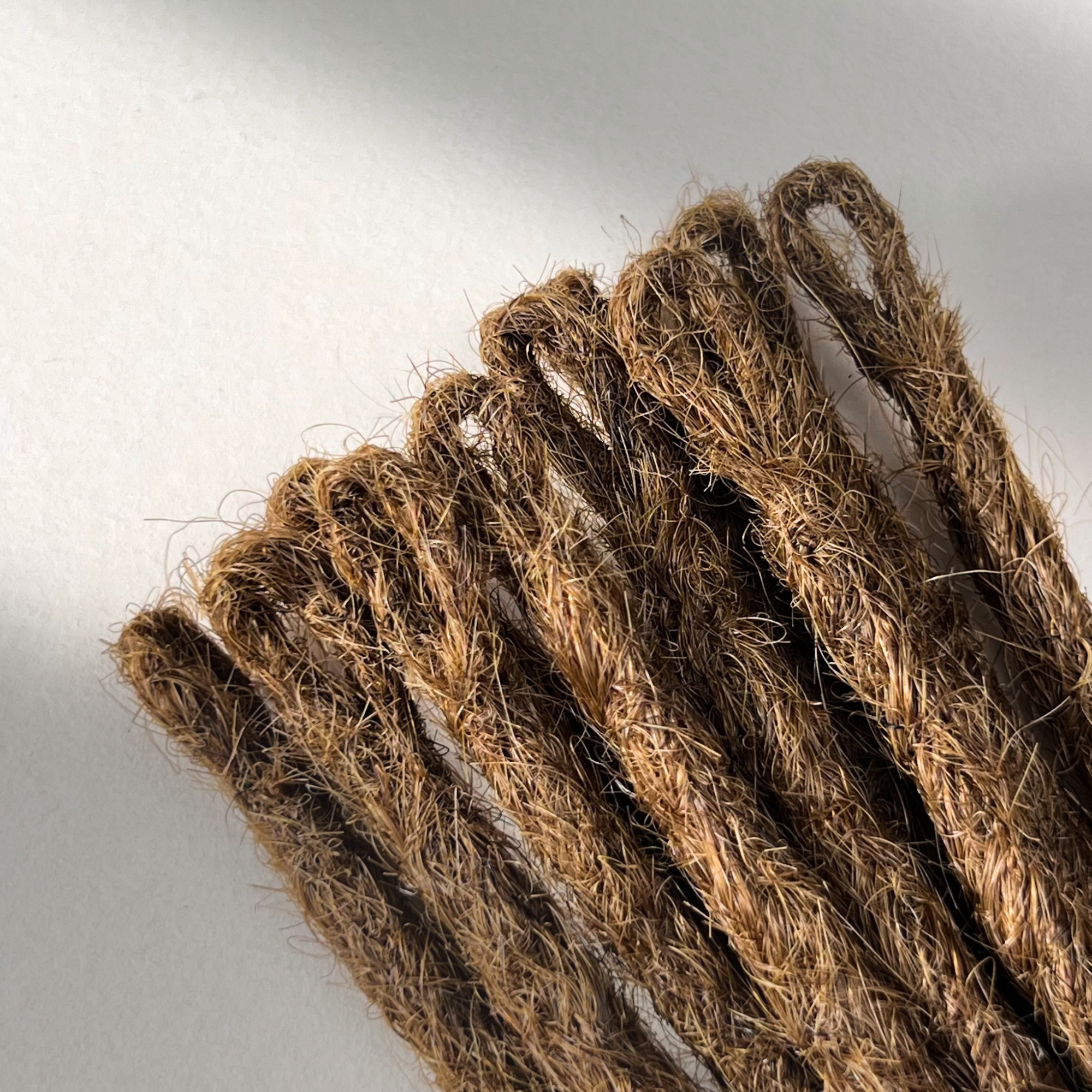 Loop detail of temporary single-ended straight loc extensions in Warm Golden Brown.