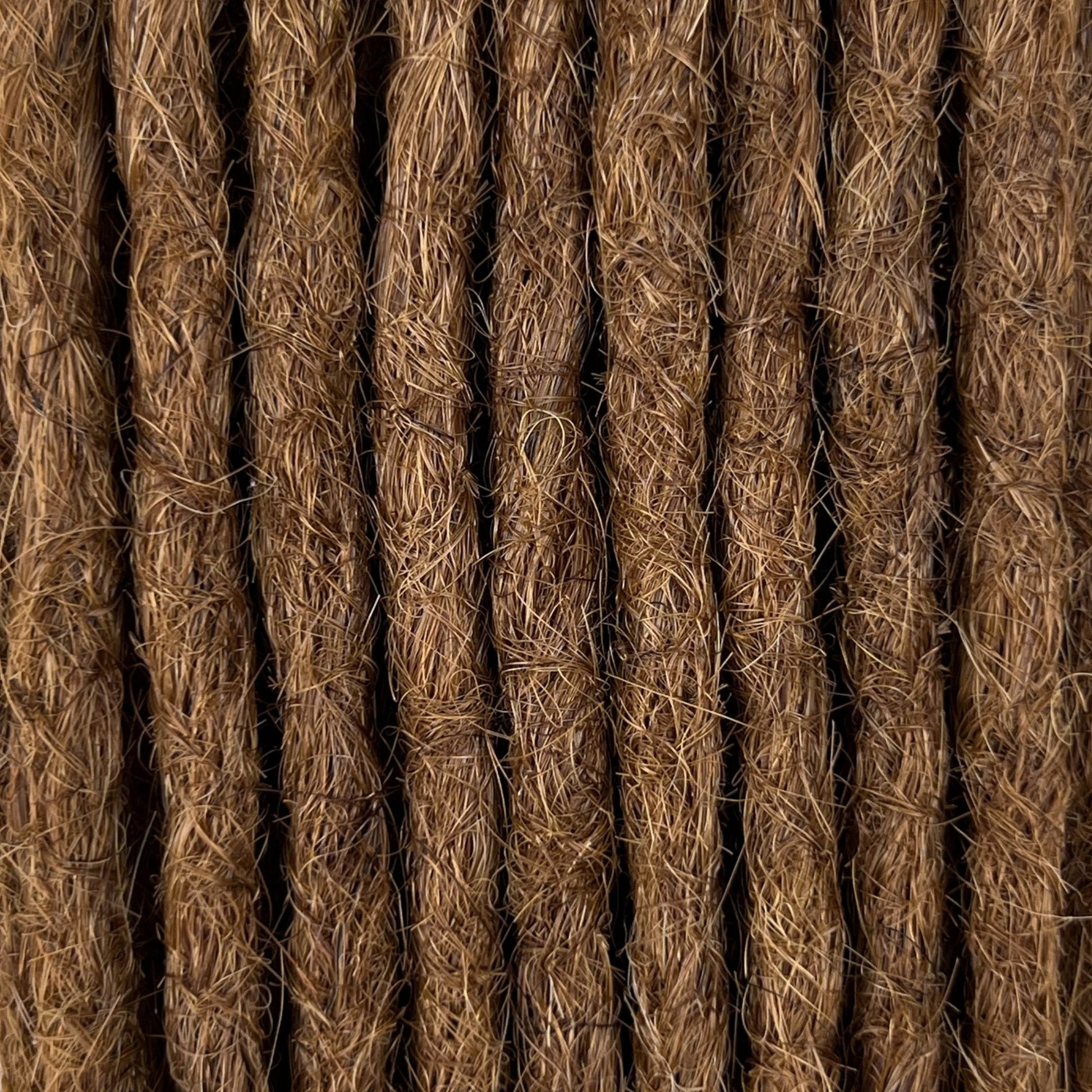 Close-up of straight loc extensions in Warm Golden Brown, showing the texture and color.