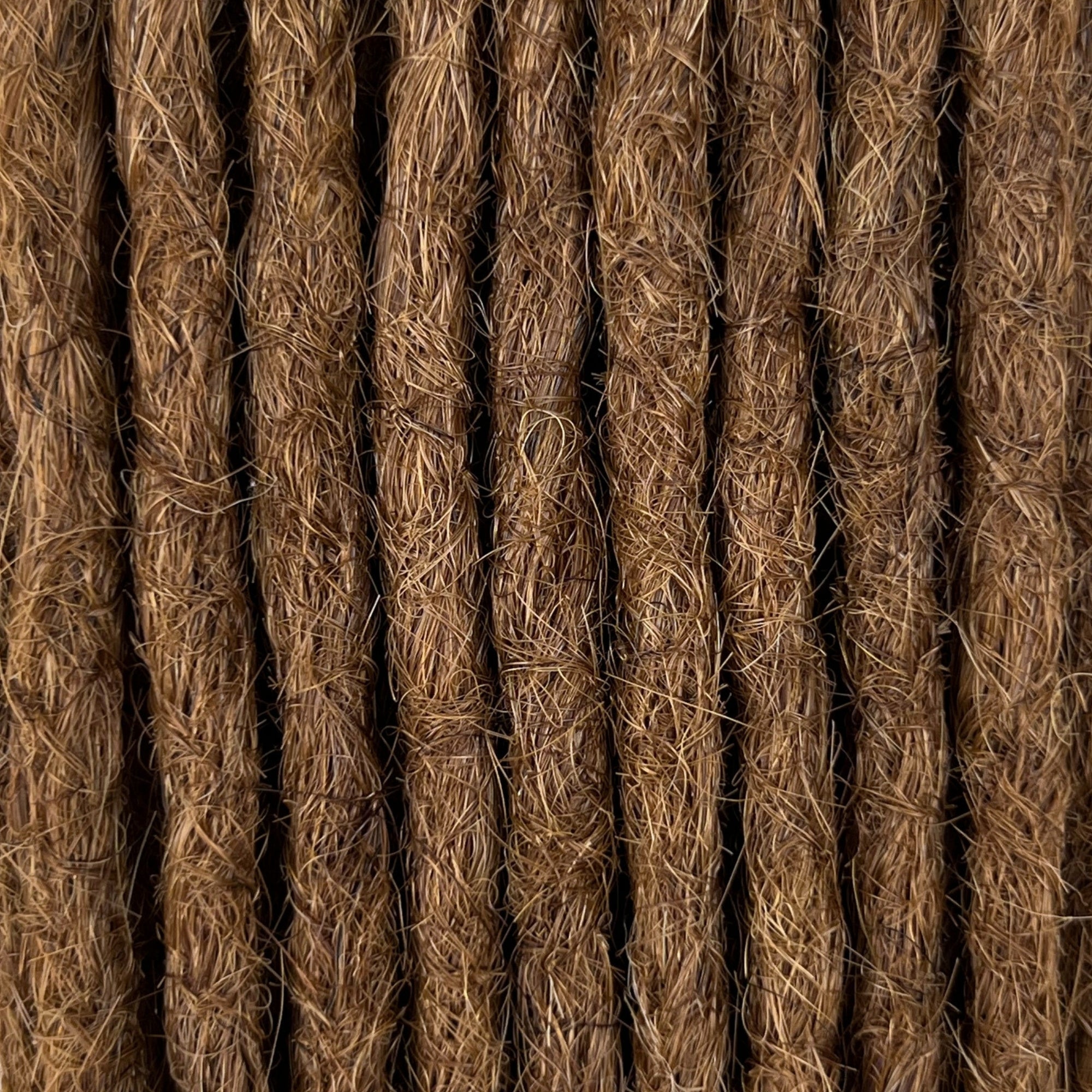 Close-up of straight loc extensions in Warm Golden Brown, showing the texture and color.