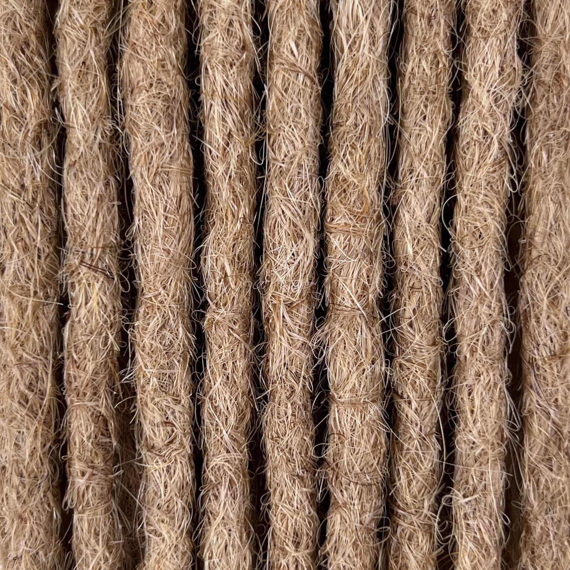 Close-up of straight loc extensions in Golden Blonde, showing the texture and color.