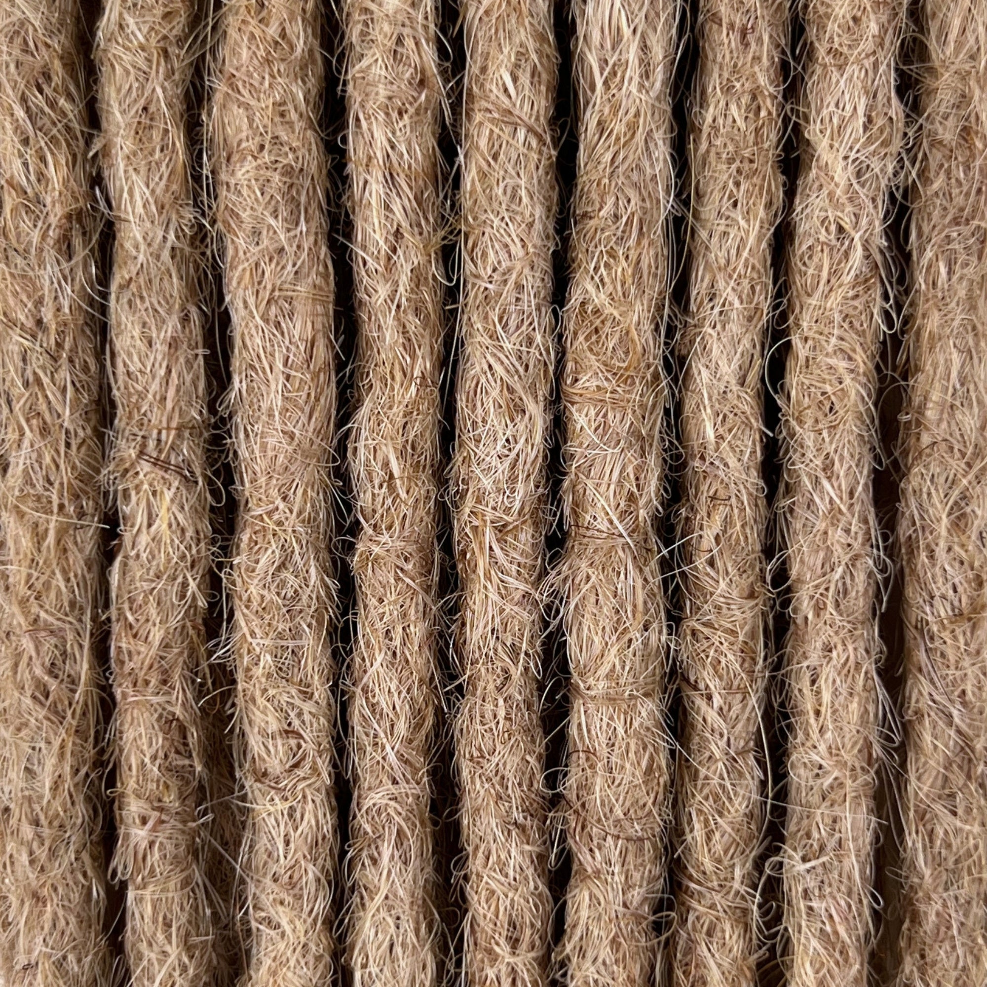 Close-up of straight loc extensions in Golden Blonde, showing the texture and color.