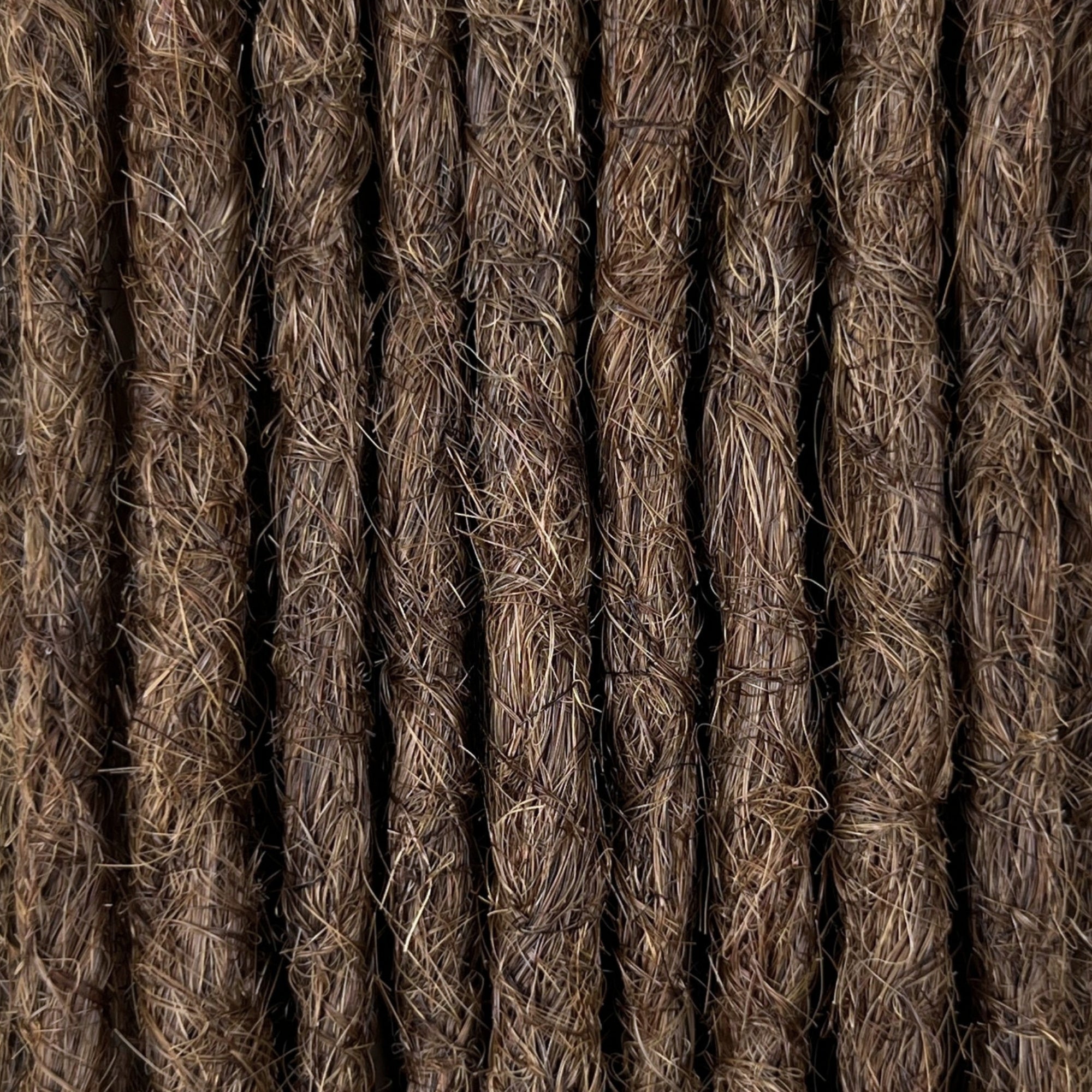 Close-up of straight loc extensions in Rich Brown, showing the texture and color.