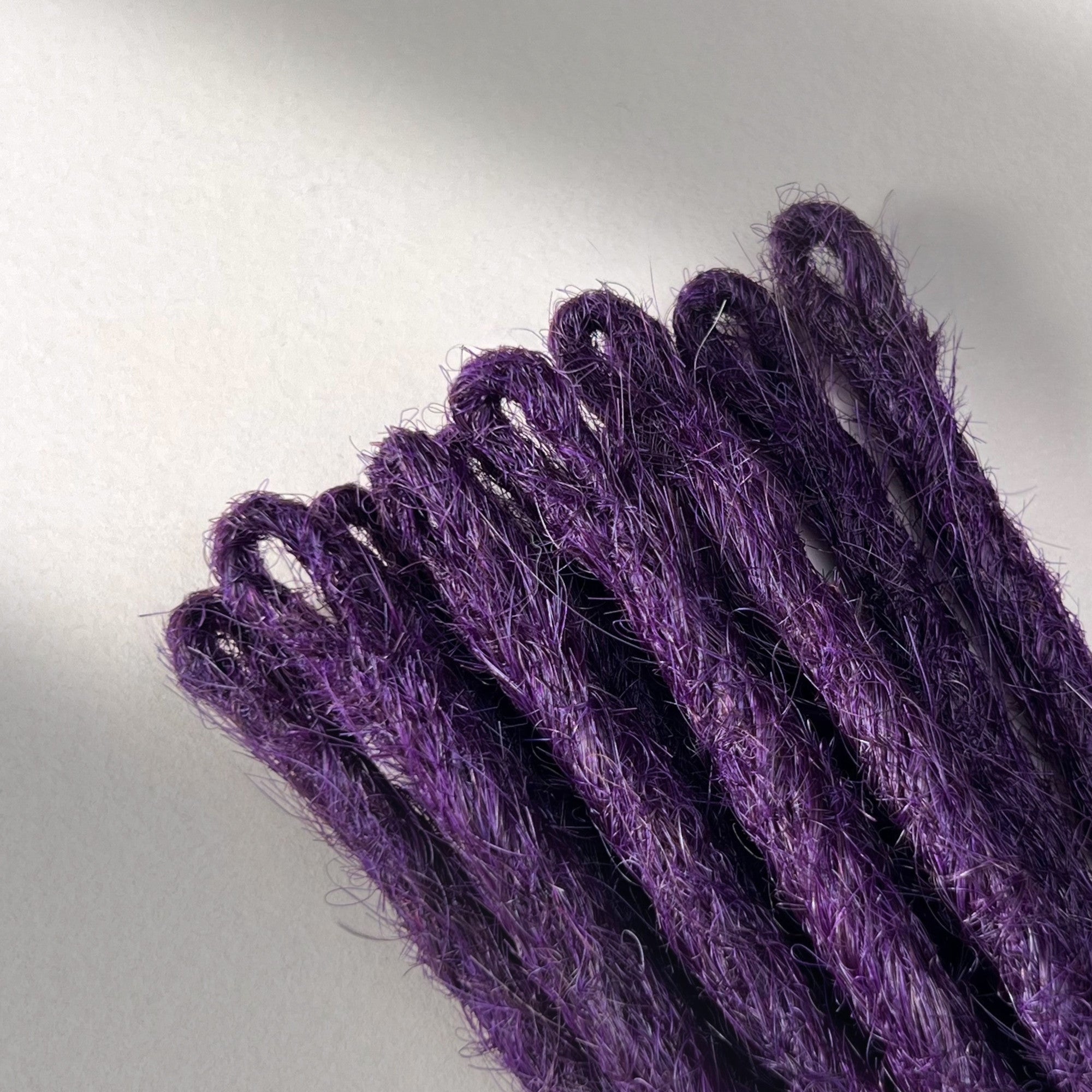 Loop detail of temporary single-ended straight loc extensions in Electric Violet.