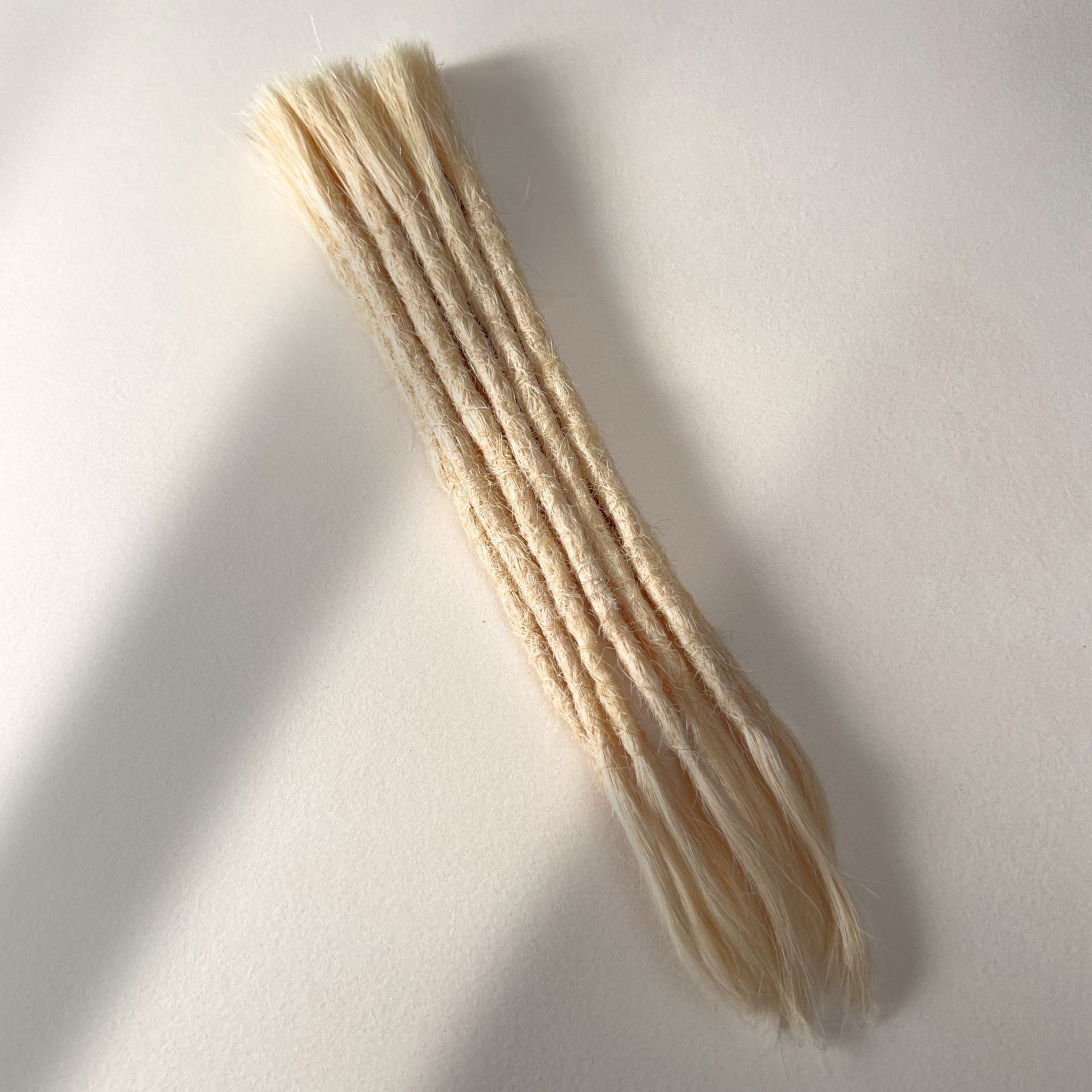 Full view of permanent straight loc extensions with open ends in Wheat Blonde.