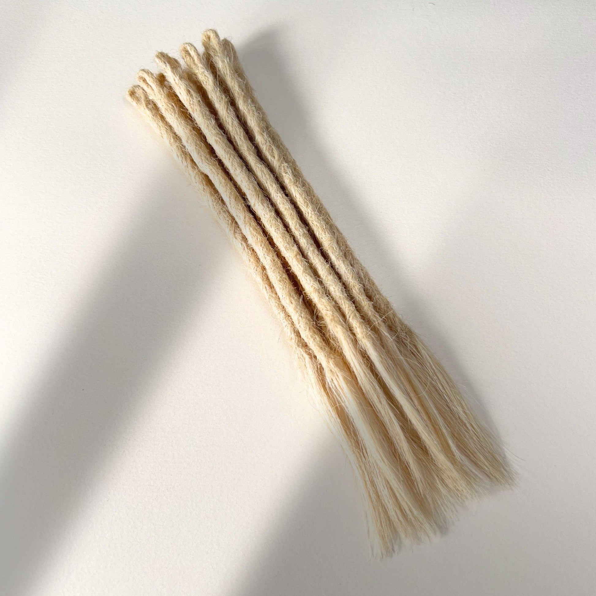 Full view of temporary single-ended straight loc extensions with open ends in Wheat Blonde.