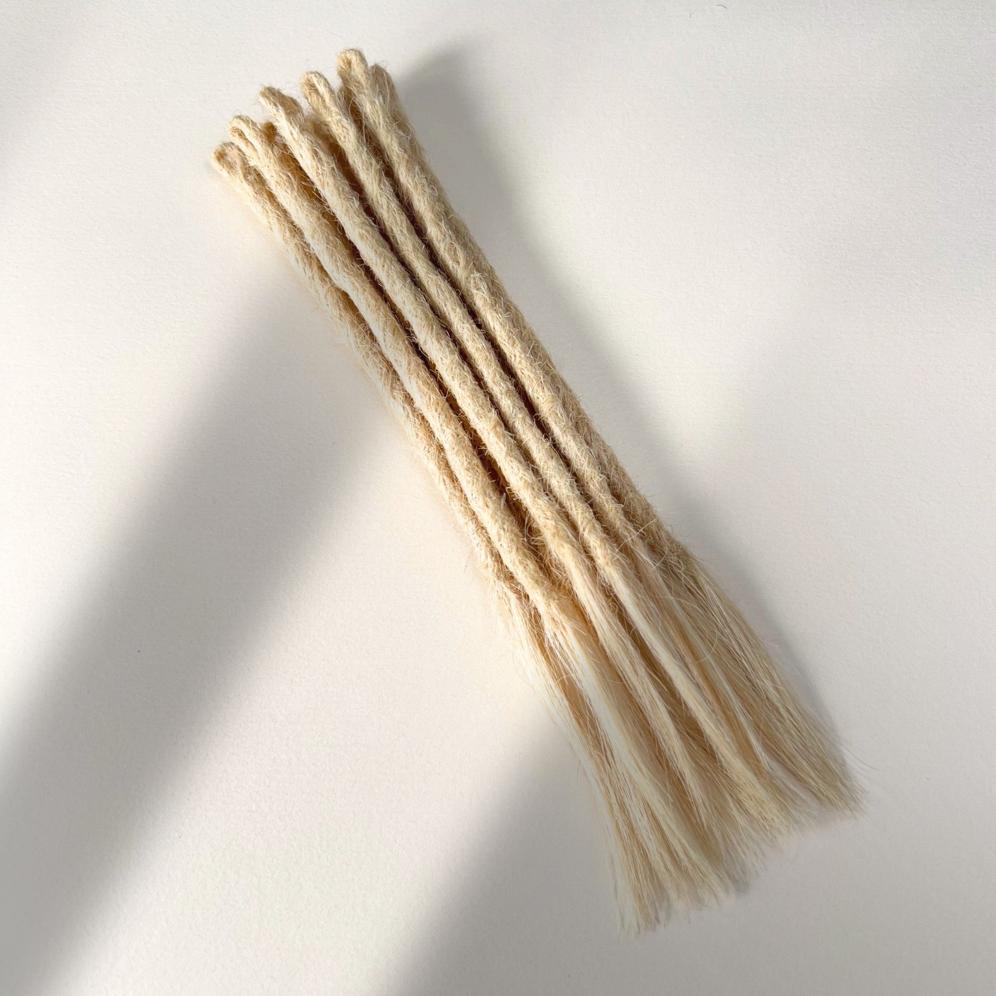 Full view of temporary single-ended straight loc extensions with open ends in Wheat Blonde.