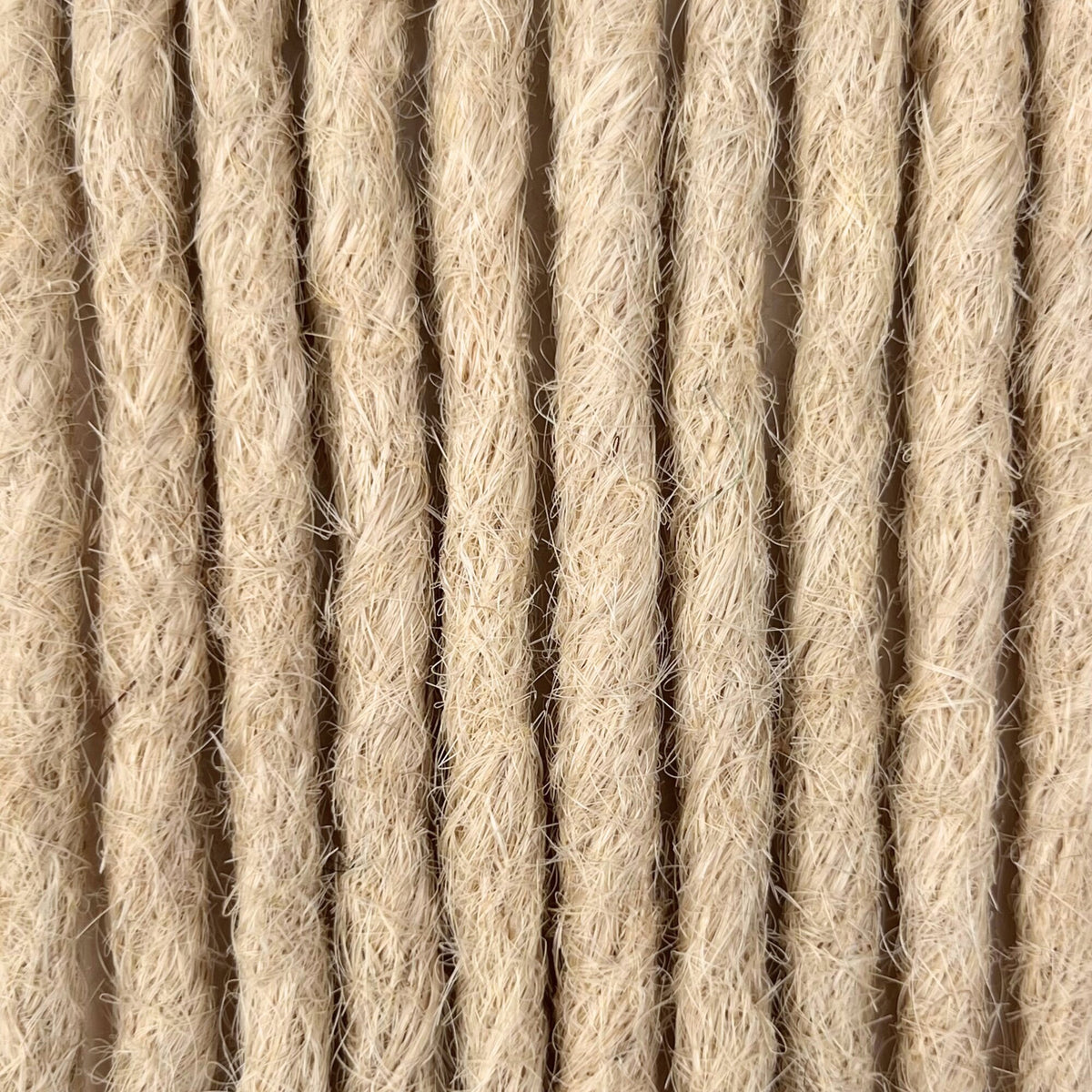 Close-up of straight loc extensions in Wheat Blonde, showing the texture and color.