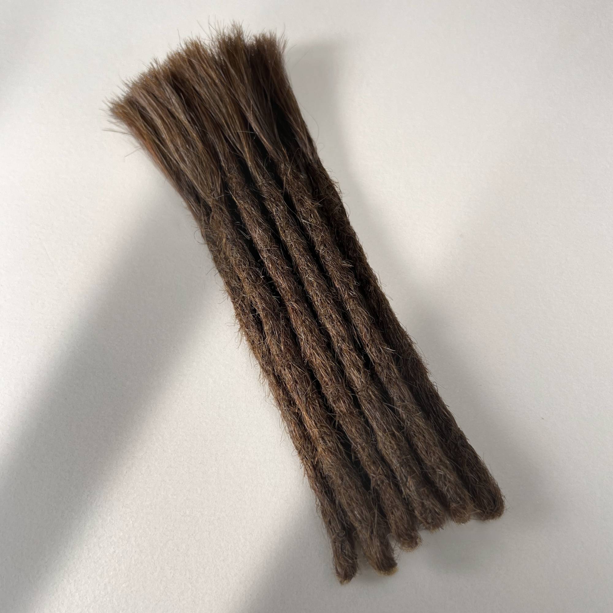 Full view of permanent straight loc extensions with blunt ends in Medium Brown.