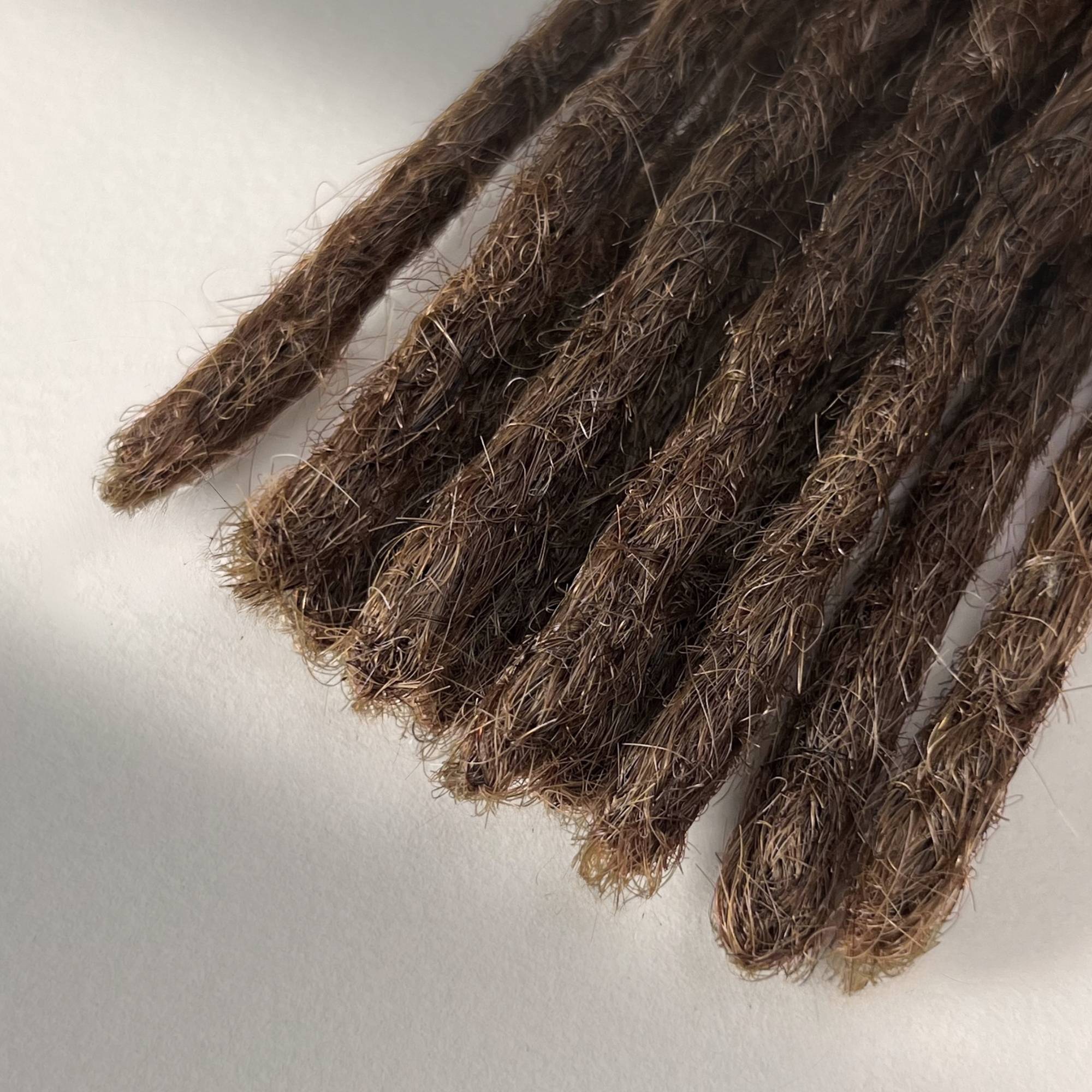 Tip detail of straight loc extensions with blunt ends in Medium Brown.