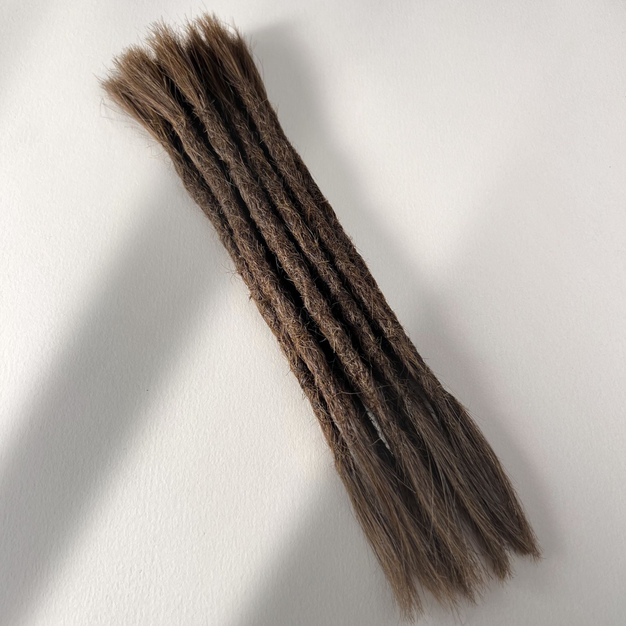 Full view of permanent straight loc extensions with open ends in Medium Brown.