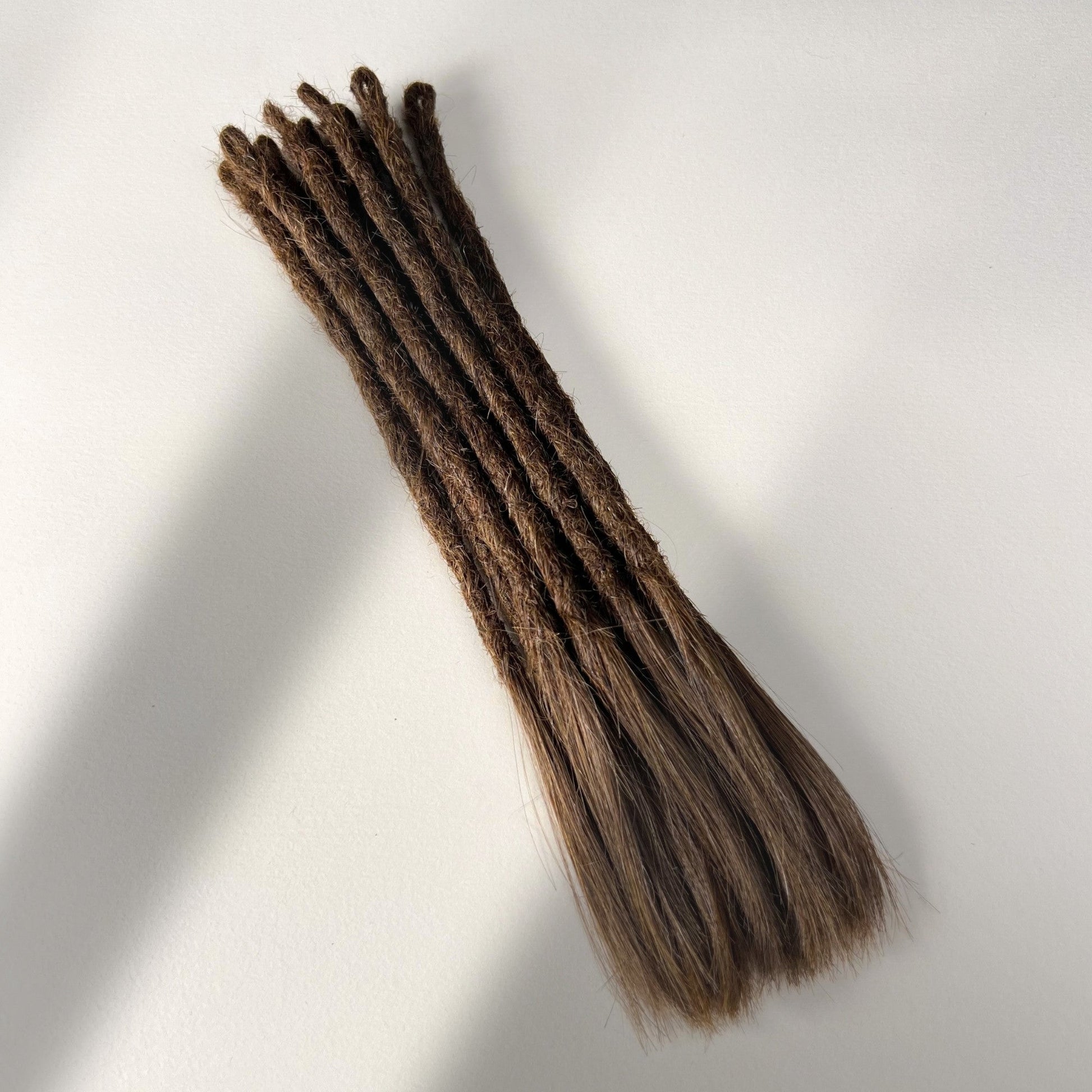 Full view of temporary single-ended straight loc extensions with open ends in Medium Brown.