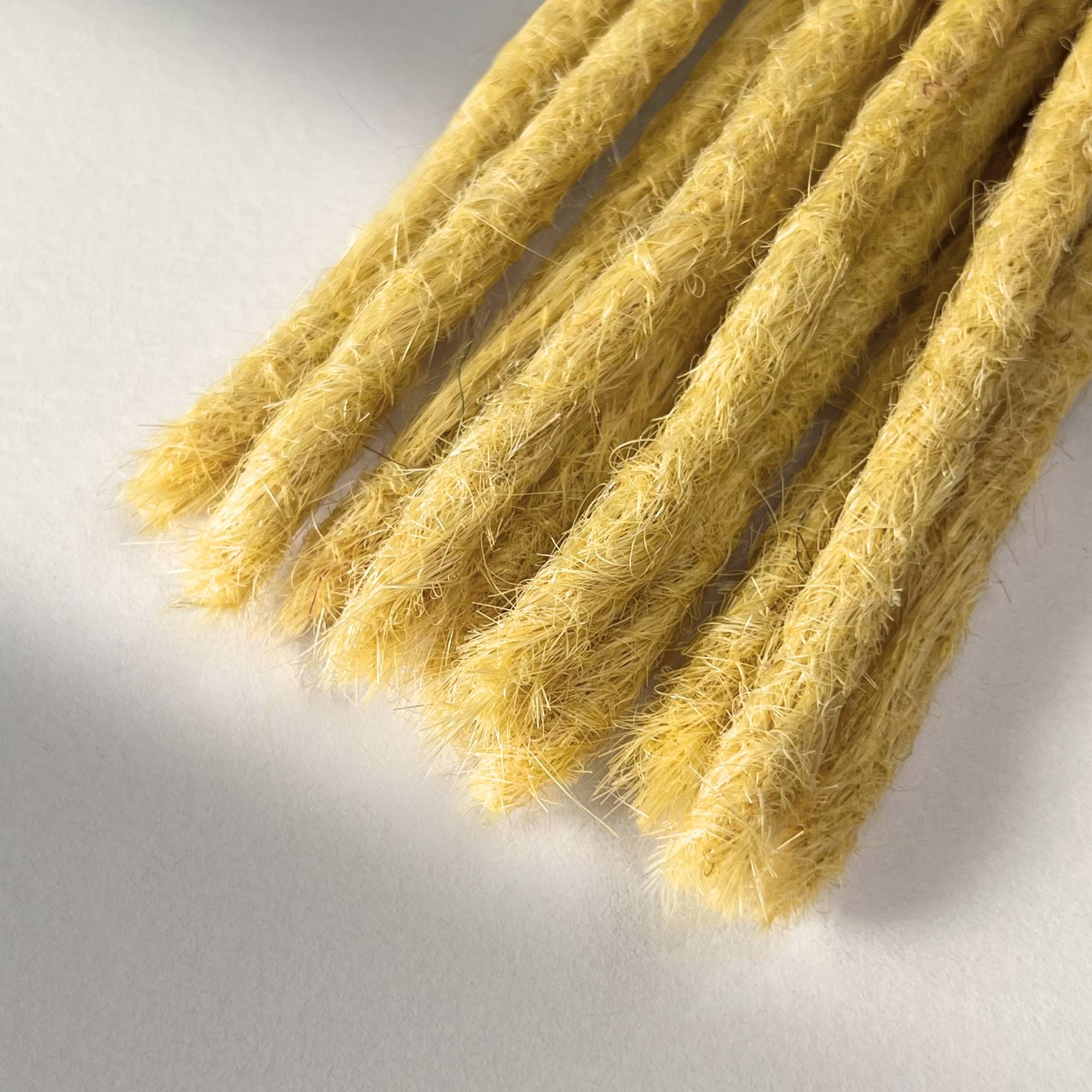 Tip detail of straight loc extensions with blunt ends in Soft Ochre.