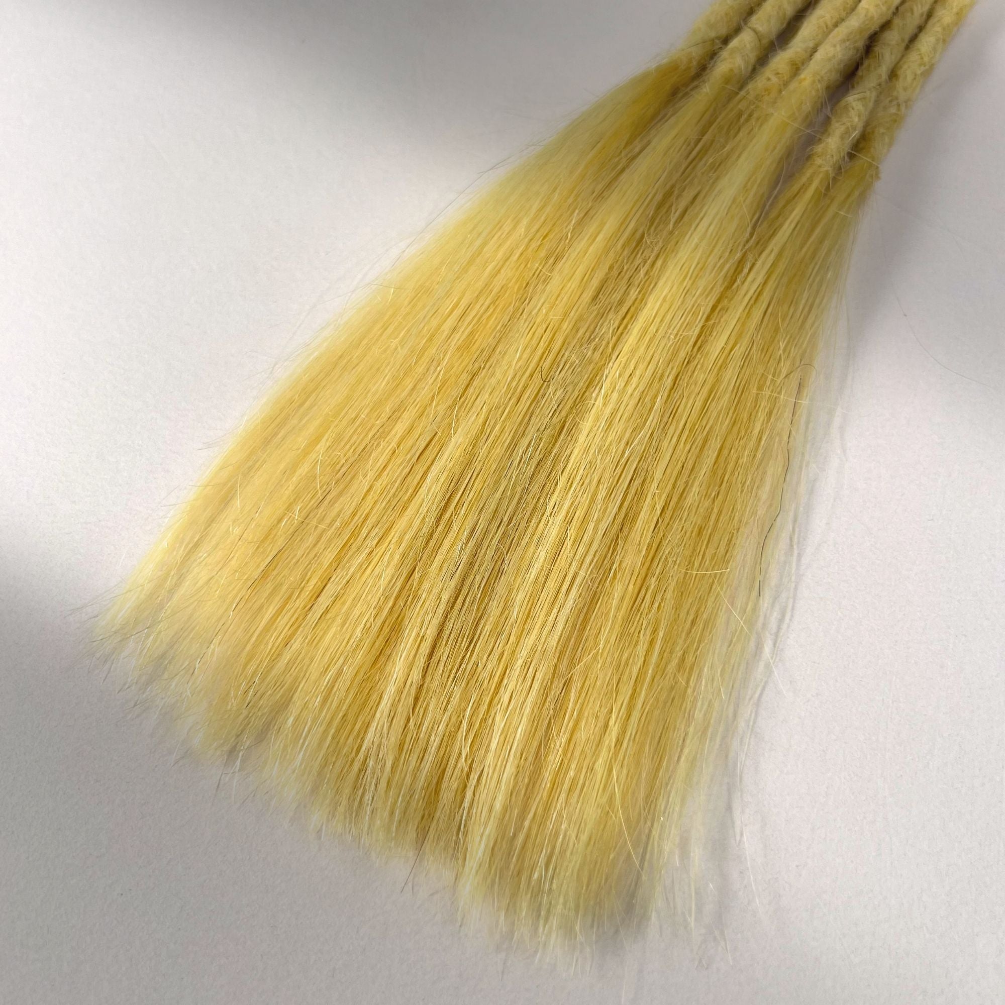 Tip detail of straight loc extensions with long loose ends in Soft Ochre.