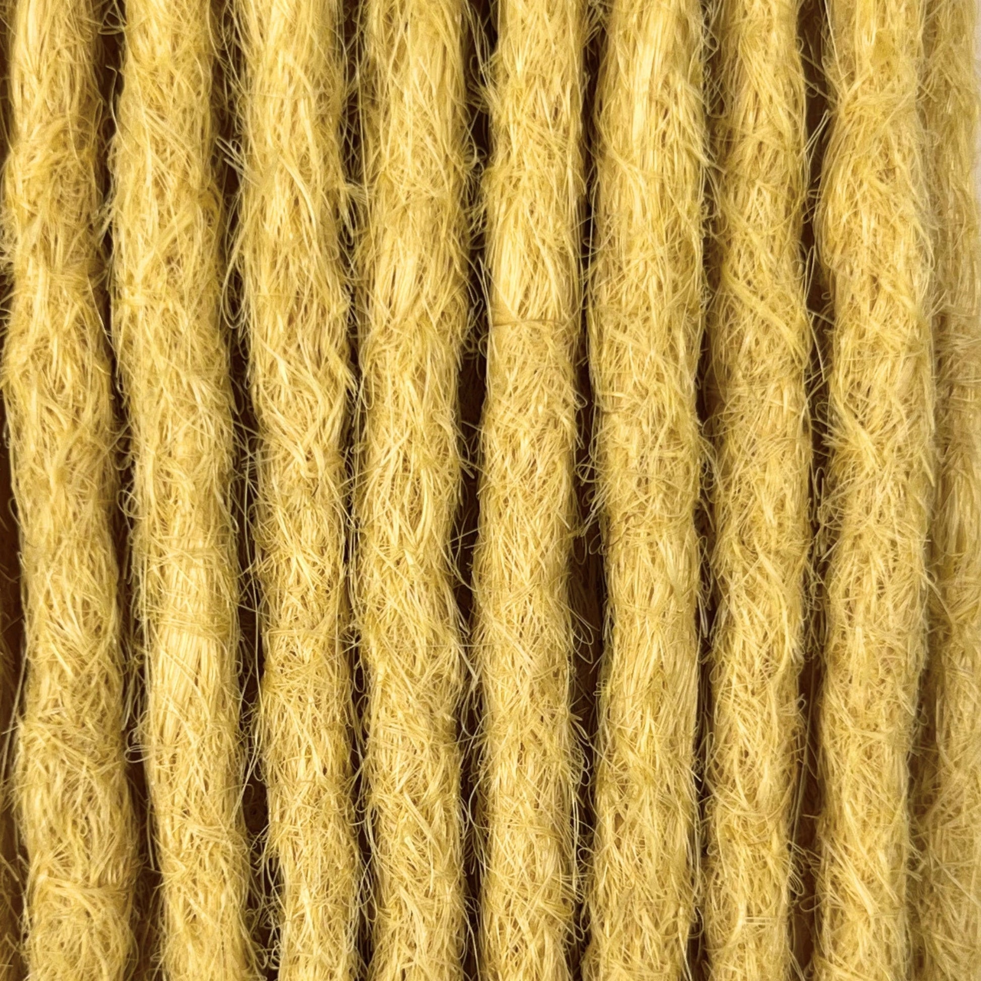 Close-up of straight loc extensions in Soft Ochre, showing the texture and color.